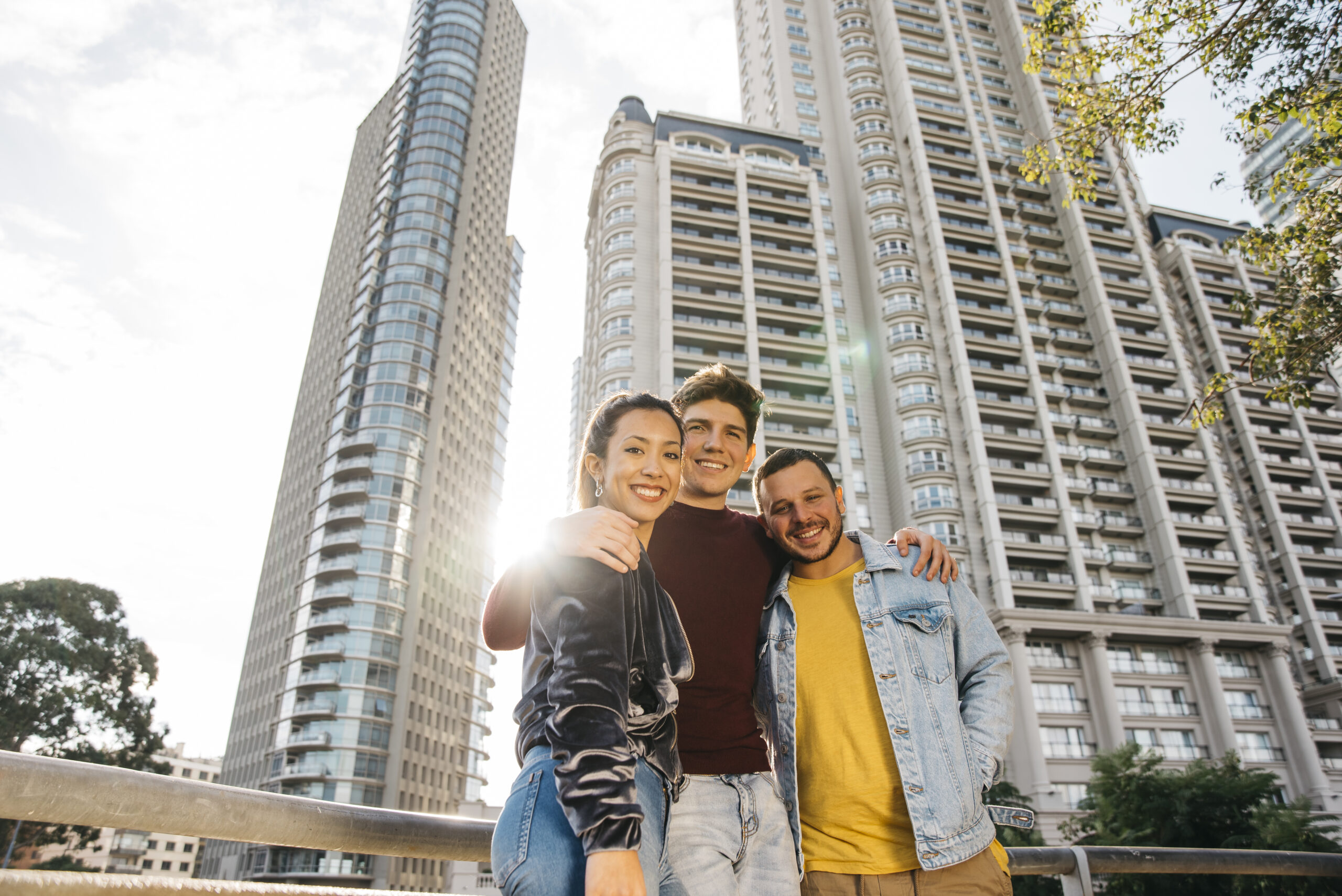 multiracial-young-friends-standing-against-city-buildings